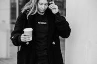 Crop charming woman with takeaway coffee on city street