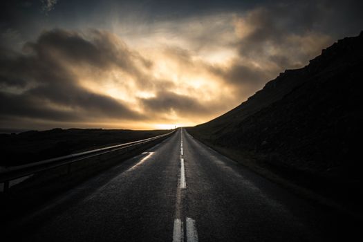 A scenic road under dramatic dawn skies, perfect for travel and adventure themes.