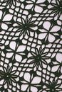 Textured background of knitted floral ornament with holes
