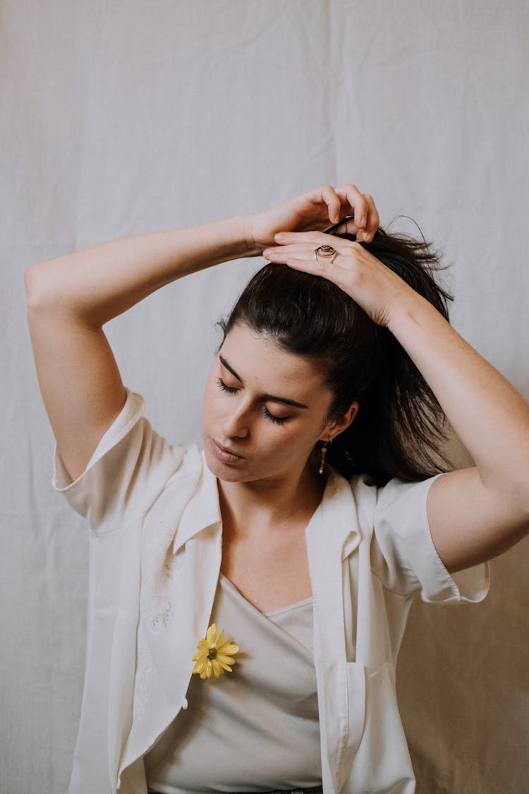 Woman Doing Ponytail Hairstyle In Light Room