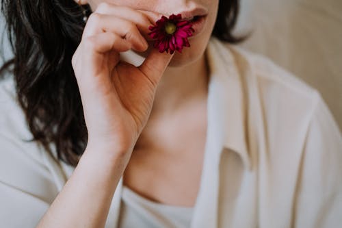 Vrouw Die In Witte Tanktop Roze Bloem Houdt