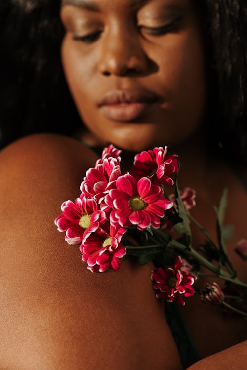 Crop sensitive black woman with fragrant flowers