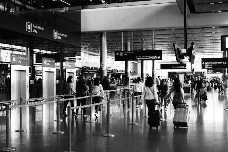 Black And White Photo Of People On Airport