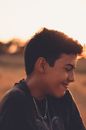 Modest smiling boy looking away