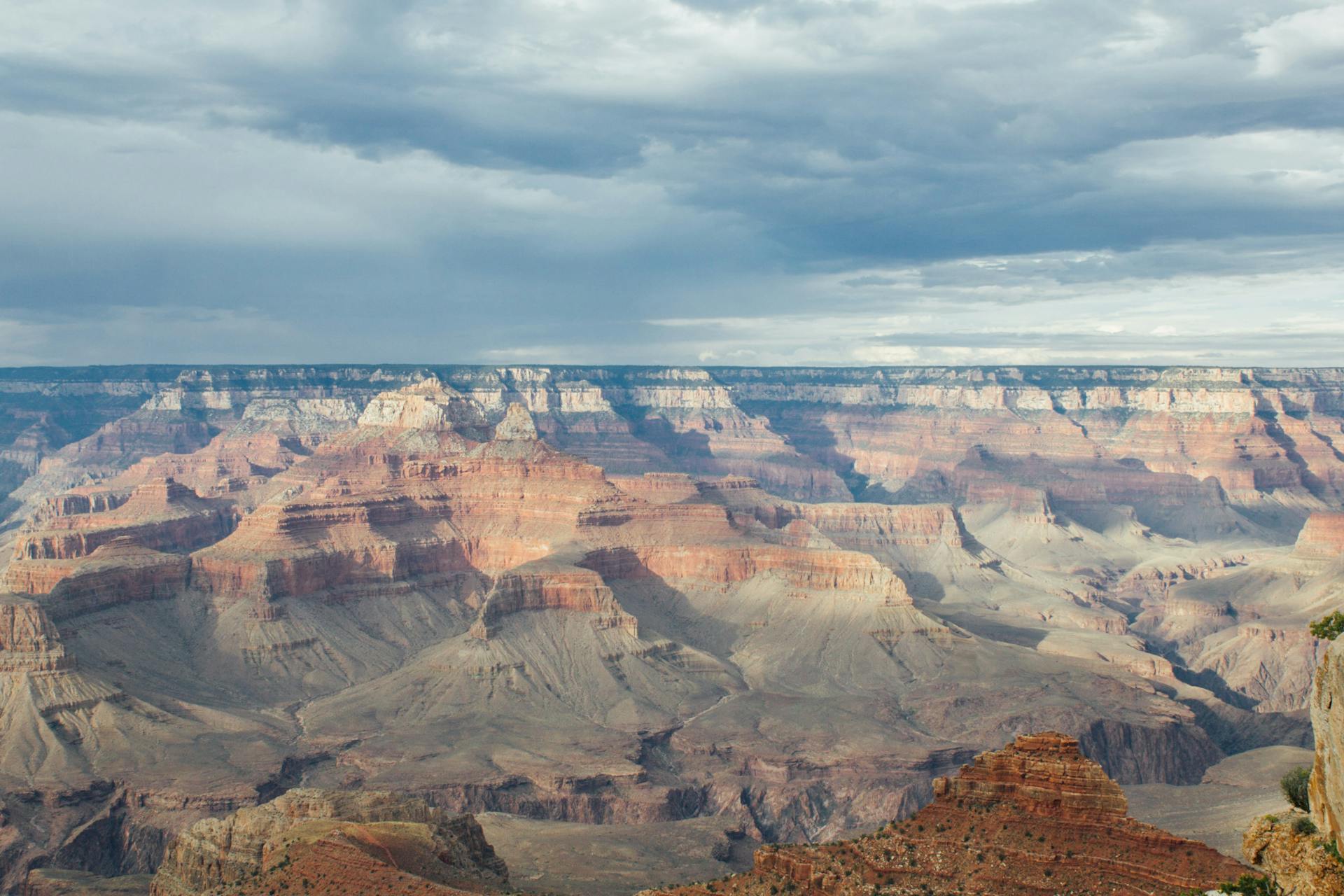 Stunning view of the Grand Canyon with dramatic clouds and colorful rock formations.