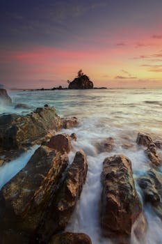 日出时，海浪拍打岩石，天空充满活力的宁静画面