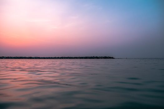 Serene ocean view with gentle ripples and a stunning sunset horizon.
