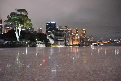 Free Stunning nighttime view of Sydney's illuminated skyline reflected on a waterfront surface. Stock Photo
