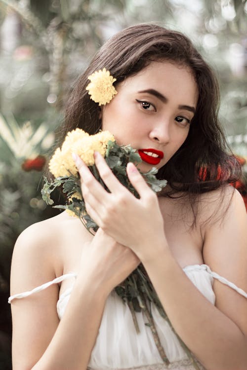 Безкоштовне стокове фото на тему «азіатська жінка, вертикальні постріл, жовті квіти»