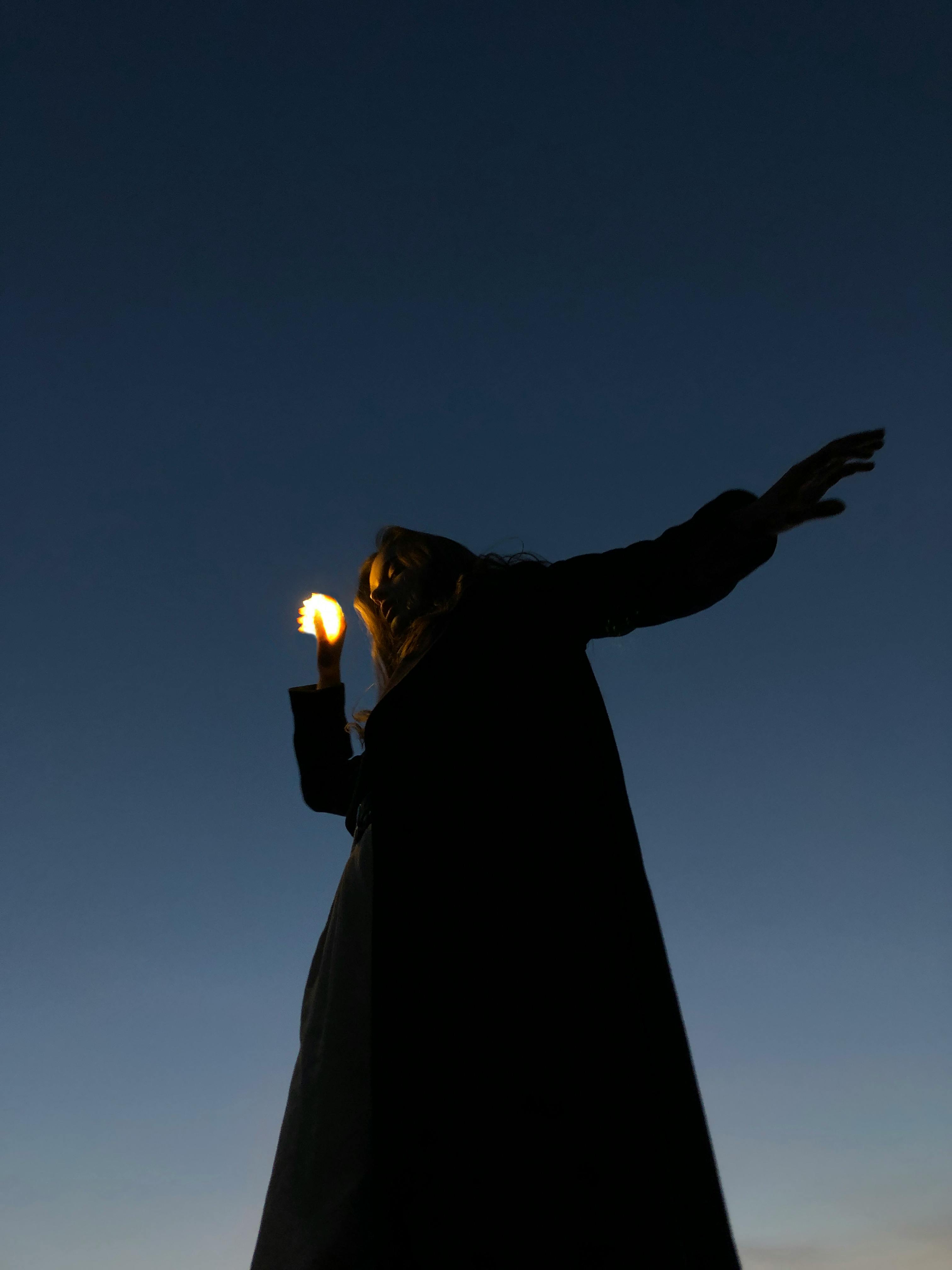 calm woman with small lamp at night