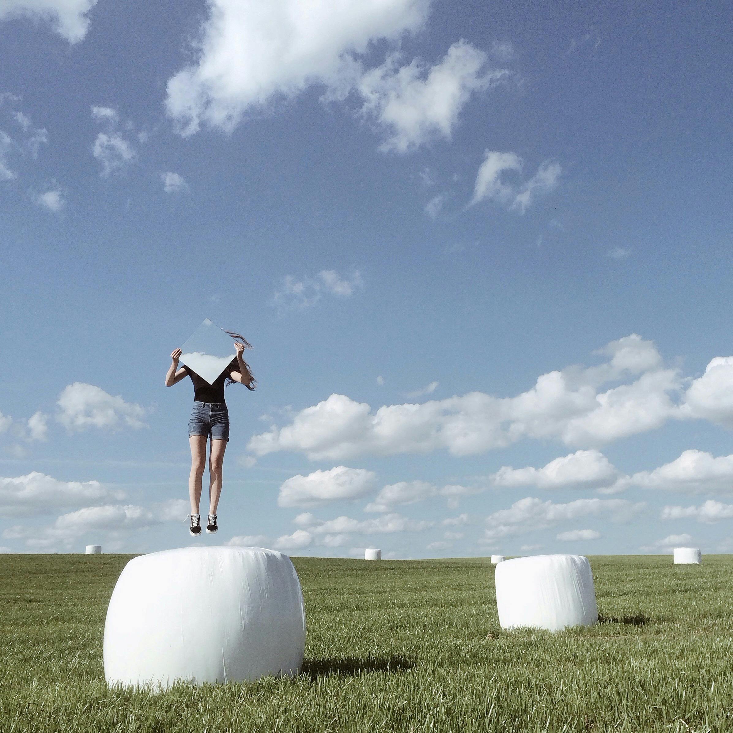 woman jumping with mirror on field