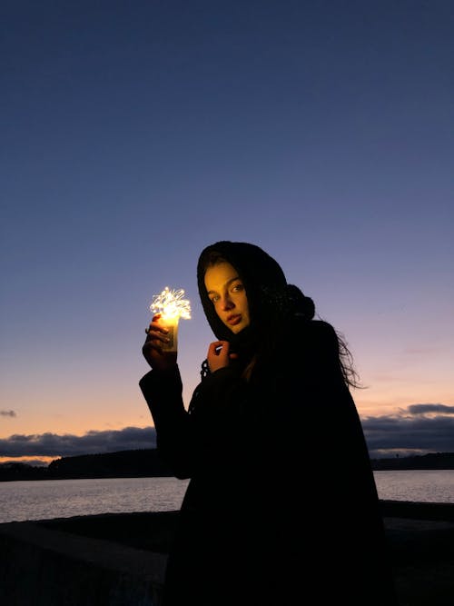 Calm woman with sparkler on street