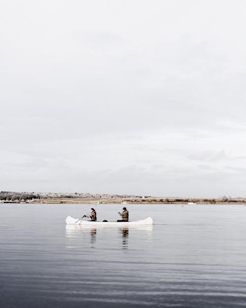 Free People Ridding on a White Boat on Lake Stock Photo