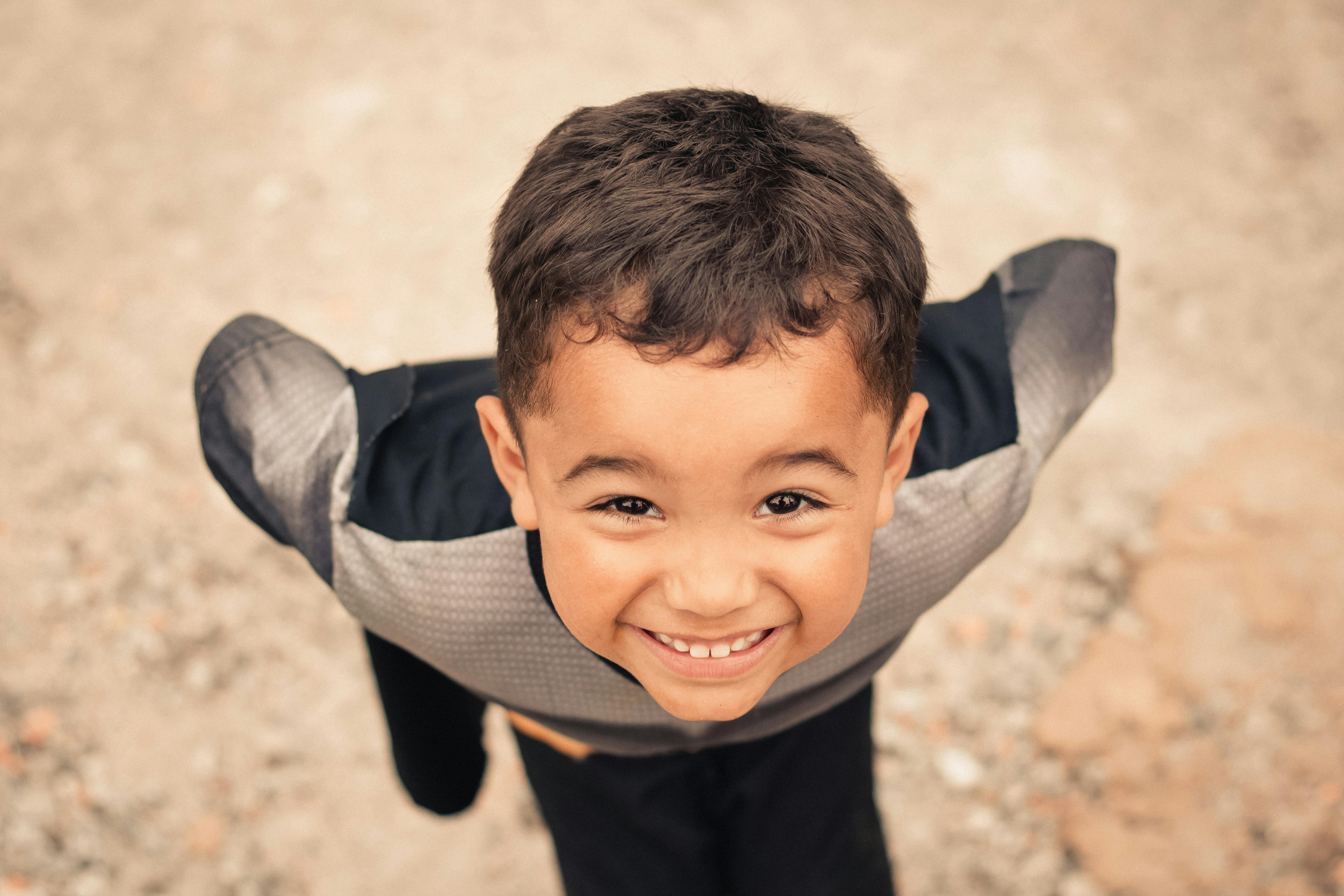 happy ethnic boy with hands on waist