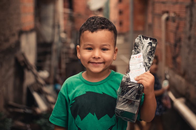 Ethnic Boy With Toy Car In Street