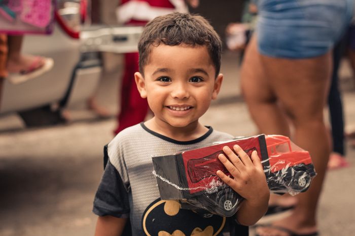 A smiling boy holding a new toy truck