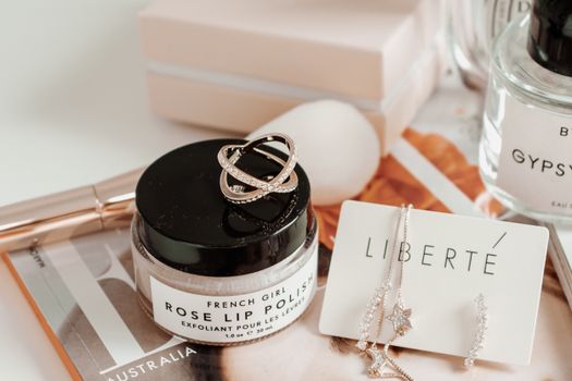 A stylish display of rose lip polish and elegant jewelry in a sophisticated setting.