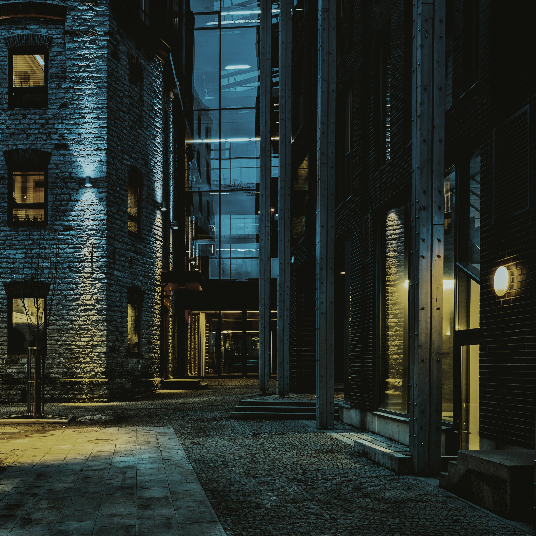 A modern complex of buildings lit at night, showcasing contemporary urban architecture.