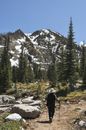 Anonymous trekker walking on path against snowy mountain