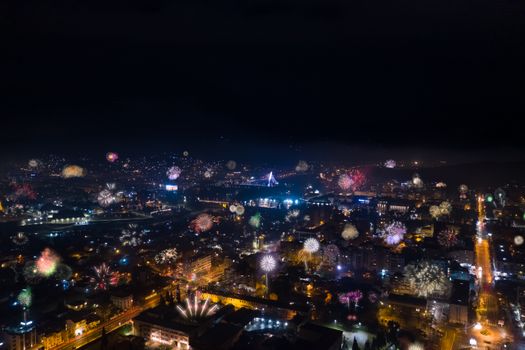 A breathtaking aerial view of Podgorica lit up by vibrant fireworks on a festive night scene.