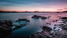日落时分，宁静的海景与水域和岩石海岸相映成趣，是理想的自然与景观主题