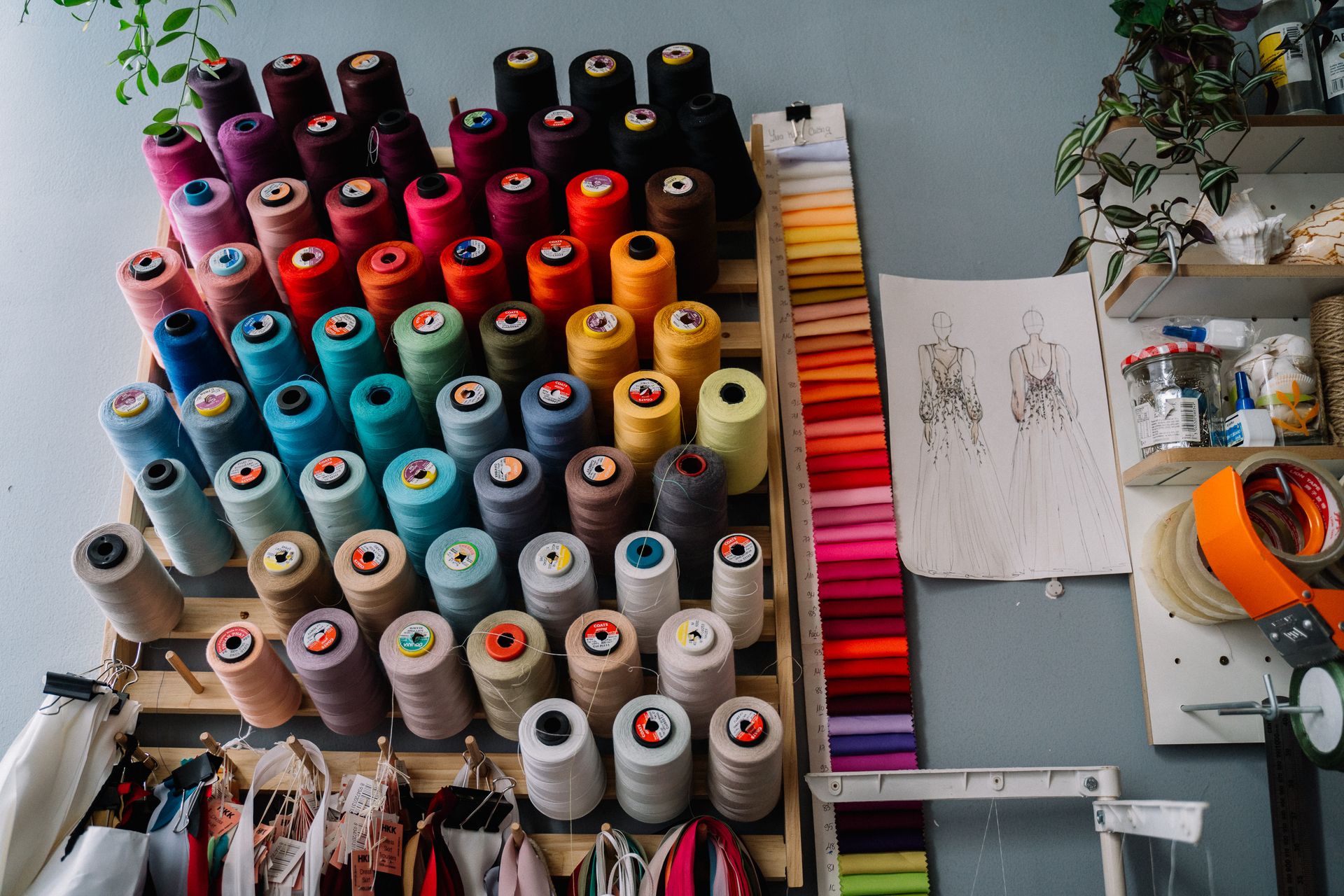 Colorful spools of sewing thread and fabric samples in a creative workspace.