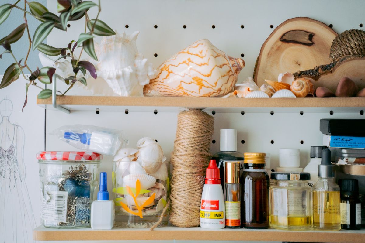 Craft supply storage shelves with jars tools and materials