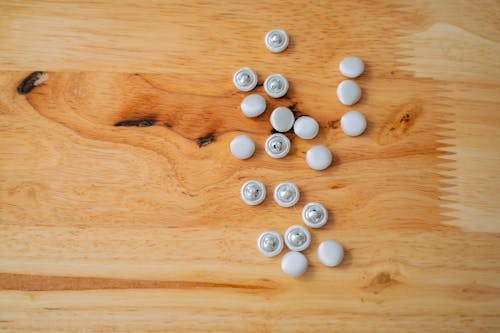 Close-Up Photo of Buttons on a Wooden Surface
