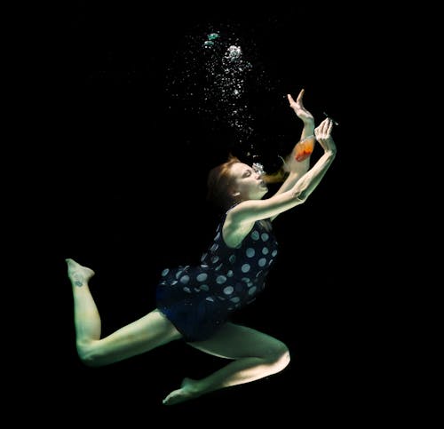 A Woman Holding a Wine Glass Underwater