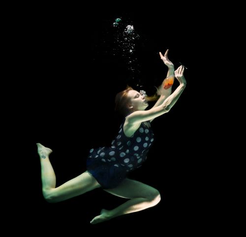 Free Artistic underwater pose of a woman with a wine glass, surrounded by bubbles. Stock Photo