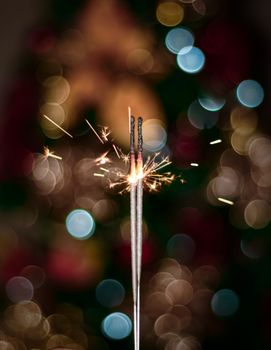 Close-up of a sparkler with colorful bokeh effect, ideal for festive celebration themes.
