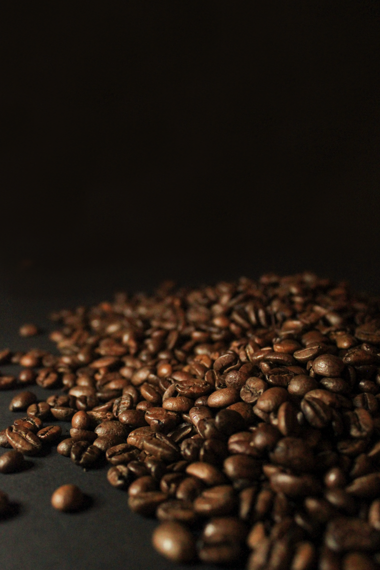 Dark roasted coffee beans piled on a dark surface — photo by Jasmijn Van der Maaten on Pexels