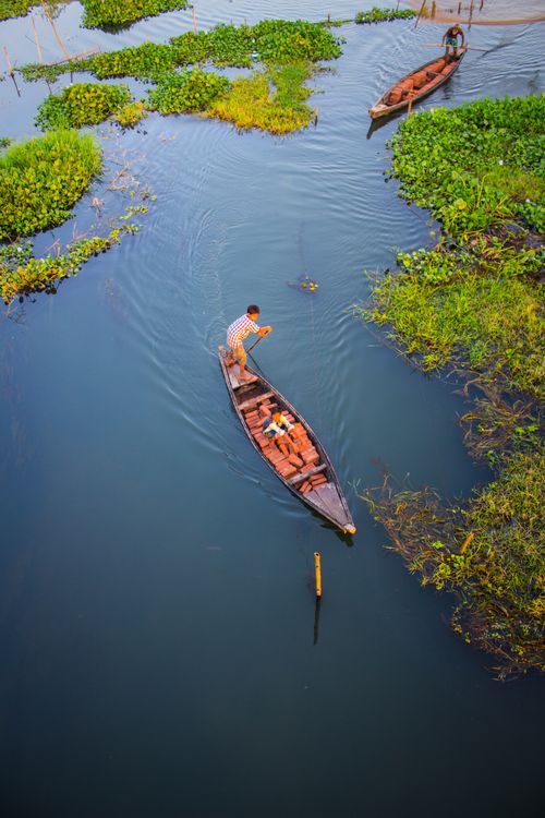 Free Captured from above, a fisherman navigates tranquil waters in a lush Indian river scene. Stock Photo
