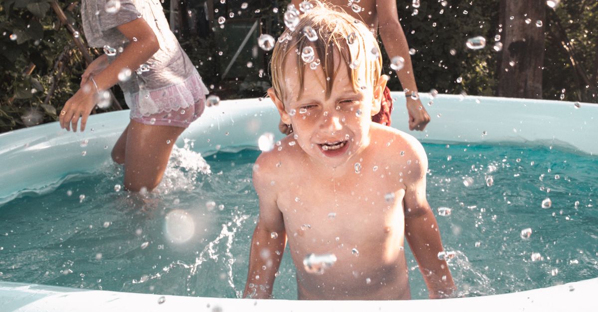 Piscina inflável infantil Crianças brincando em uma piscina inflável ao ar livre em dia de sol
