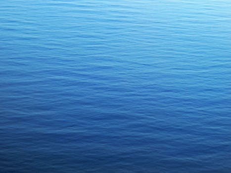 Calm blue ocean surface with gentle ripples, capturing serenity and tranquility.