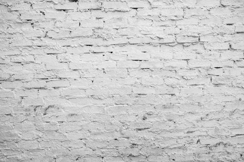 Free A detailed close-up of a white brick wall with rough stucco texture, ideal for backgrounds. Stock Photo