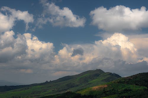 An Aerial Photography of a Mountain Under the Blue Sky and White Clouds