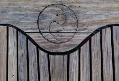 Free Natural wooden texture featuring a carved yin yang symbol, perfect for design backgrounds. Stock Photo