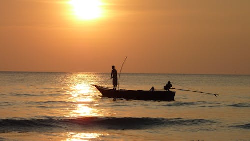 Kostenlos Schattenbildfotografie Von Zwei Fischern Auf Dem Boot Während Des Sonnenuntergangs Stock-Foto