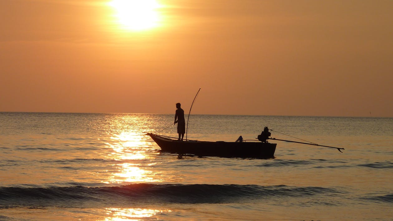 Gratis Fotografi Siluet Dua Nelayan Di Kapal Saat Matahari Terbenam Foto Stok