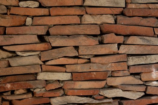 Close-up of a rustic brick wall with rough, earthy texture.