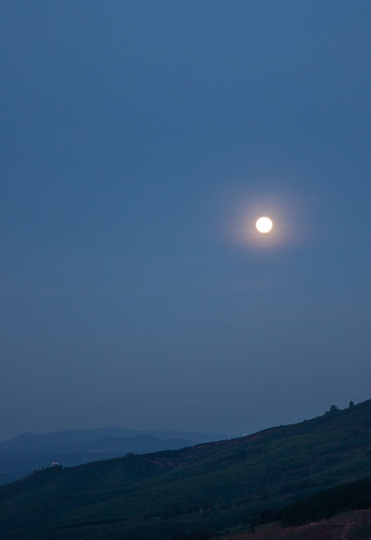 A Beautiful View Of The Full Moon Over The Mountain