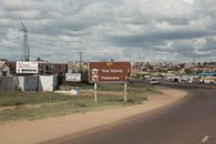 Road sign on R71 highway towards Polokwane with town in background under cloudy sky.