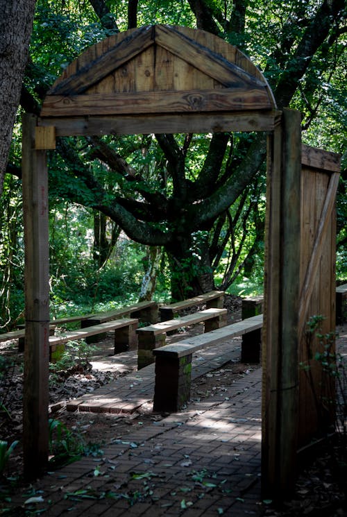 Wooden Gateway to a Park with Wooden Benches on the Pavement 