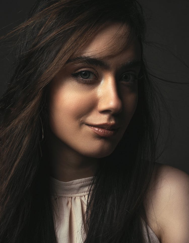 Confident Woman In Makeup And Blouse In Studio