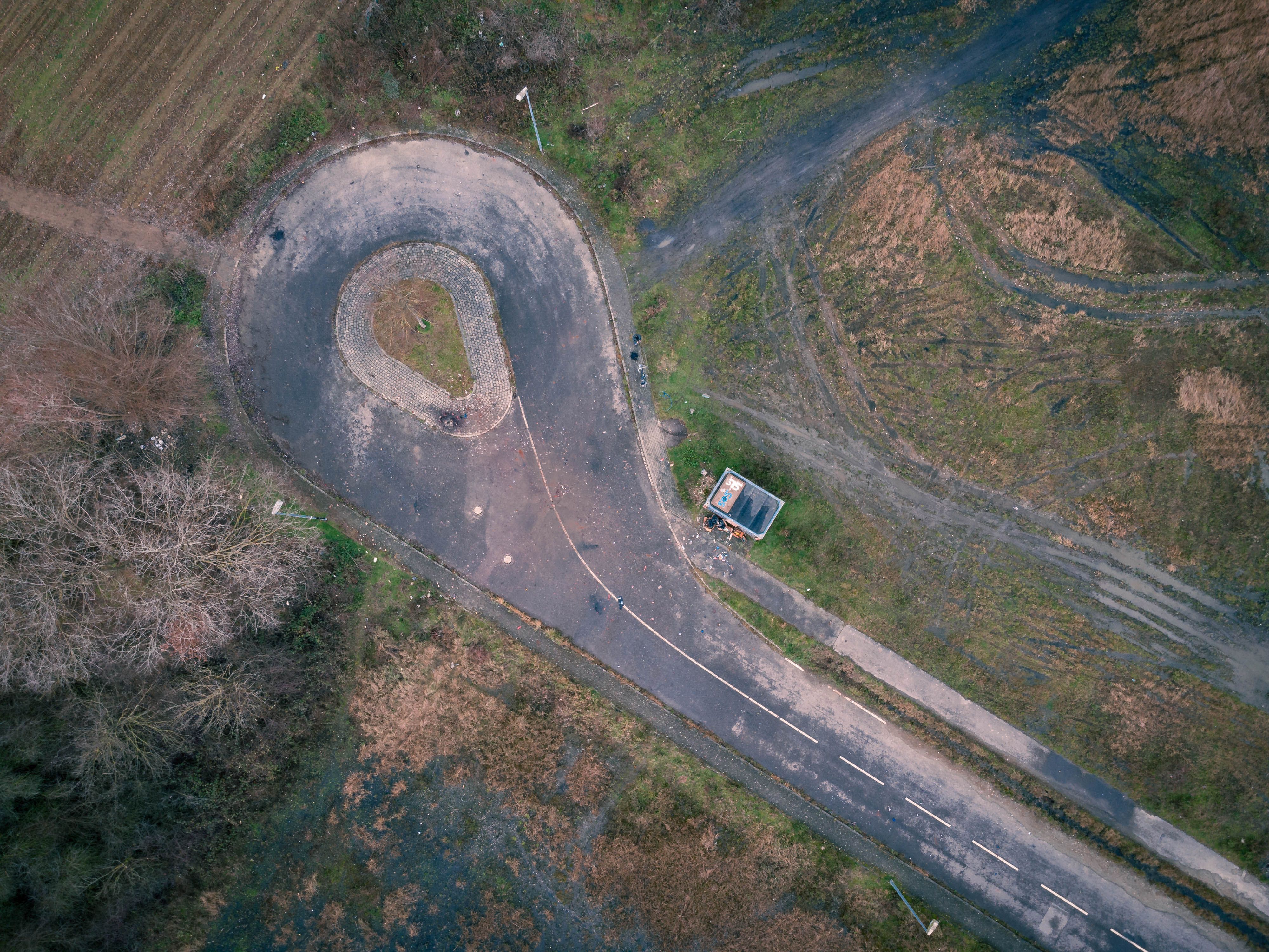 Aerial View of Green Grass Field and Gray Asphalt Road · Free Stock Photo