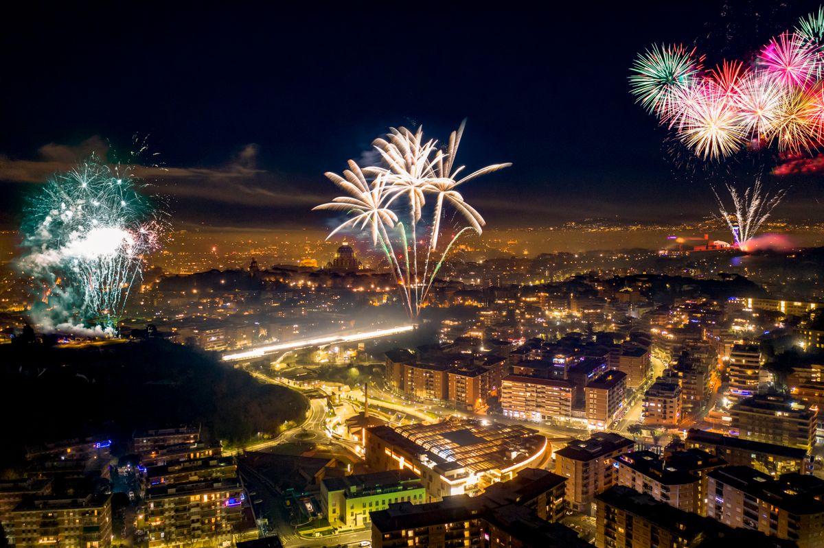 Italian festival fireworks display celebration over historic city skyline at night