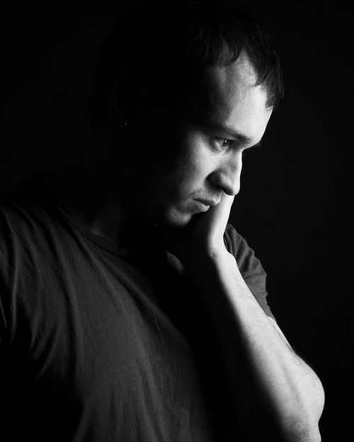 Free A thoughtful black and white portrait of a man deep in contemplation in a studio setting. Stock Photo