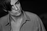 这幅单色肖像描绘了一位穿着衬衫、沉思的男人，传达出深沉的情感