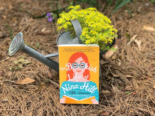 A Book Leaning Against a Watering Can 